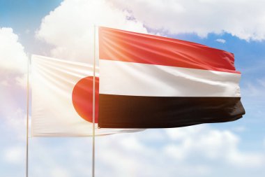 Sunny blue sky and flags of yemen and japan