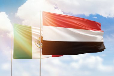 Sunny blue sky and flags of yemen and mexico