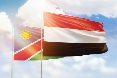 Sunny blue sky and flags of yemen and namibia