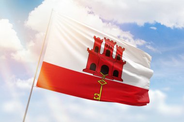 Güneşli mavi gökyüzü ve Cebelitarık bayrağıyla bayrak direği