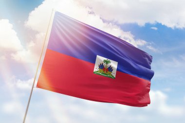 Güneşli mavi gökyüzü ve Haiti bayrağıyla bayrak direği