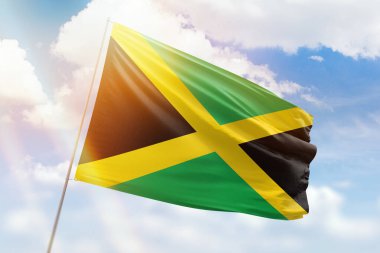 Güneşli mavi gökyüzü ve Jamaika bayrağıyla bayrak direği
