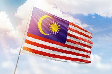 Güneşli mavi gökyüzü ve Malezya bayrağıyla bayrak direği
