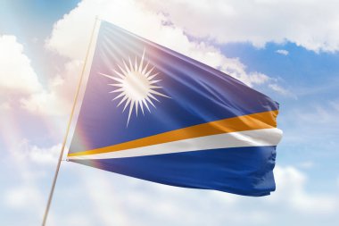 Güneşli mavi gökyüzü ve Marshall adalarının bayrağıyla bayrak direği