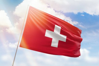 Sunny blue sky and a flagpole with the flag of switzerland