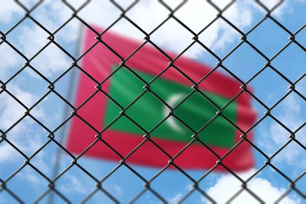 A steel mesh against the background of a blue sky and a flagpole with the flag of maldives