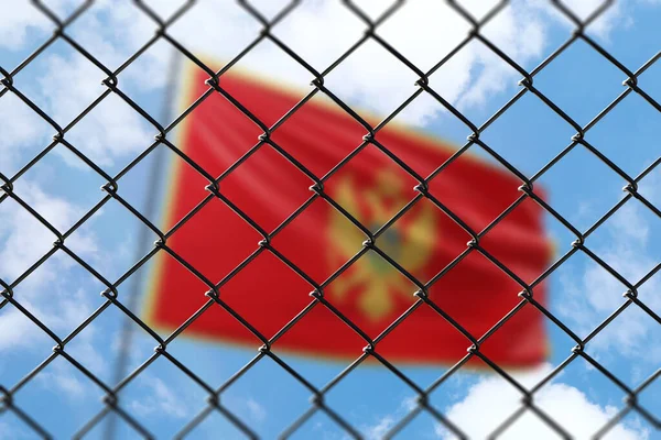 A steel mesh against the background of a blue sky and a flagpole with the flag of montenegro
