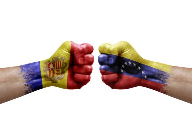Two hands punch to each others on white background. Country flags painted fists, conflict crisis concept between andorra and venezuela