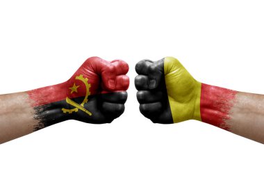 Two hands punch to each others on white background. Country flags painted fists, conflict crisis concept between angola and belgium