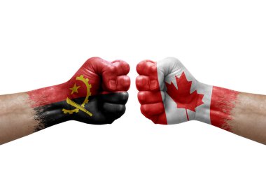 Two hands punch to each others on white background. Country flags painted fists, conflict crisis concept between angola and canada