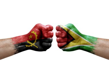Two hands punch to each others on white background. Country flags painted fists, conflict crisis concept between angola and guyana