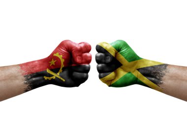 Two hands punch to each others on white background. Country flags painted fists, conflict crisis concept between angola and jamaica