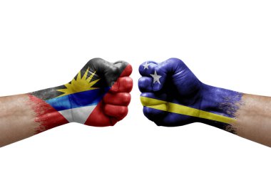 Two hands punch to each others on white background. Country flags painted fists, conflict crisis concept between antigua and barbuda and curacao