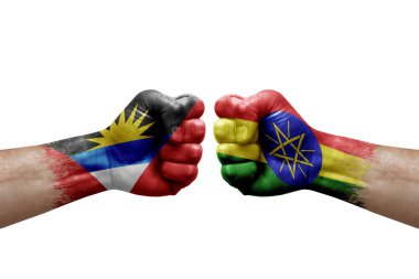 Two hands punch to each others on white background. Country flags painted fists, conflict crisis concept between antigua and barbuda and ethiopia