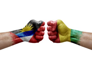 Two hands punch to each others on white background. Country flags painted fists, conflict crisis concept between antigua and barbuda and guinea