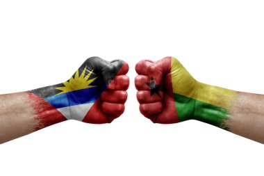 Two hands punch to each others on white background. Country flags painted fists, conflict crisis concept between antigua and barbuda and guinea-bissau