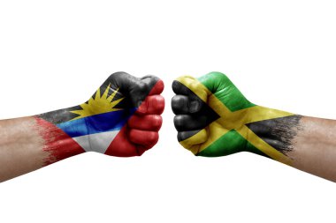 Two hands punch to each others on white background. Country flags painted fists, conflict crisis concept between antigua and barbuda and jamaica