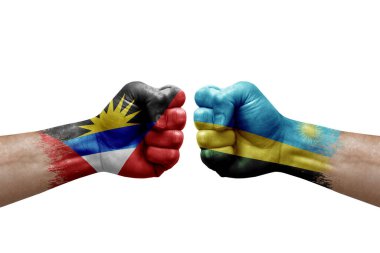 Two hands punch to each others on white background. Country flags painted fists, conflict crisis concept between antigua and barbuda and rwanda
