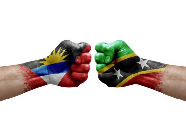 Two hands punch to each others on white background. Country flags painted fists, conflict crisis concept between antigua and barbuda and saint kitts and nevis