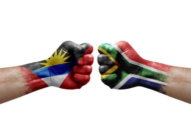 Two hands punch to each others on white background. Country flags painted fists, conflict crisis concept between antigua and barbuda and south africa
