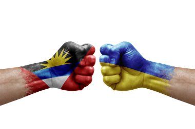Two hands punch to each others on white background. Country flags painted fists, conflict crisis concept between antigua and barbuda and ukraine
