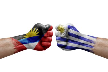 Two hands punch to each others on white background. Country flags painted fists, conflict crisis concept between antigua and barbuda and uruguay
