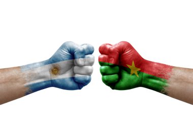 Two hands punch to each others on white background. Country flags painted fists, conflict crisis concept between argentina and burkina faso