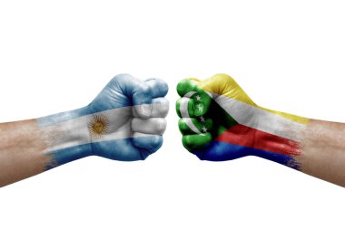 Two hands punch to each others on white background. Country flags painted fists, conflict crisis concept between argentina and comoros