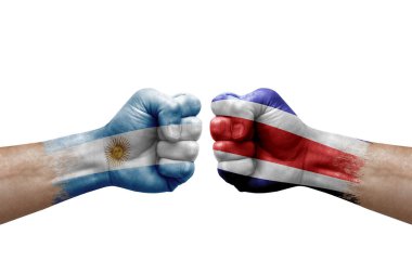 Two hands punch to each others on white background. Country flags painted fists, conflict crisis concept between argentina and costa rica