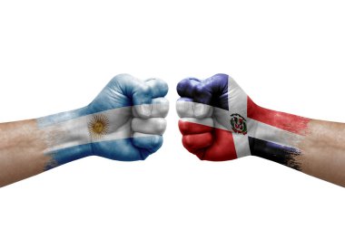 Two hands punch to each others on white background. Country flags painted fists, conflict crisis concept between argentina and dominican republic