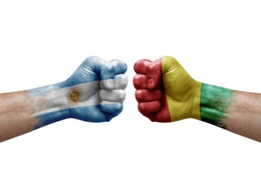 Two hands punch to each others on white background. Country flags painted fists, conflict crisis concept between argentina and guinea