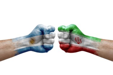 Two hands punch to each others on white background. Country flags painted fists, conflict crisis concept between argentina and iran