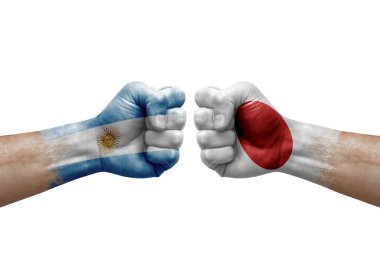 Two hands punch to each others on white background. Country flags painted fists, conflict crisis concept between argentina and japan
