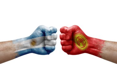 Two hands punch to each others on white background. Country flags painted fists, conflict crisis concept between argentina and kyrgyzstan