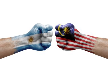 Two hands punch to each others on white background. Country flags painted fists, conflict crisis concept between argentina and malaysia