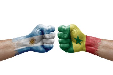 Two hands punch to each others on white background. Country flags painted fists, conflict crisis concept between argentina and senegal