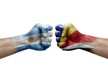 Two hands punch to each others on white background. Country flags painted fists, conflict crisis concept between argentina and seychelles