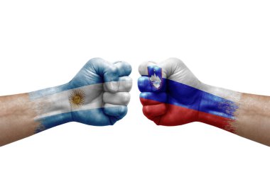 Two hands punch to each others on white background. Country flags painted fists, conflict crisis concept between argentina and slovenia