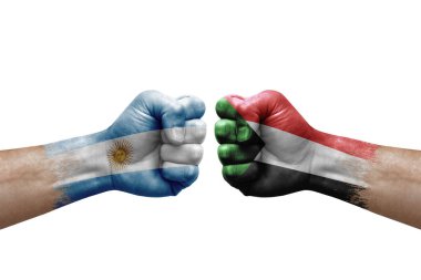 Two hands punch to each others on white background. Country flags painted fists, conflict crisis concept between argentina and sudan