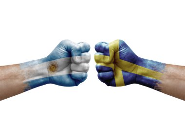 Two hands punch to each others on white background. Country flags painted fists, conflict crisis concept between argentina and sweden
