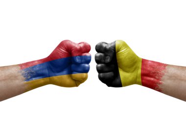 Two hands punch to each others on white background. Country flags painted fists, conflict crisis concept between armenia and belgium