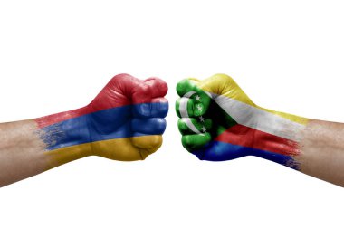 Two hands punch to each others on white background. Country flags painted fists, conflict crisis concept between armenia and comoros