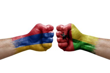 Two hands punch to each others on white background. Country flags painted fists, conflict crisis concept between armenia and guinea-bissau