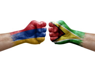 Two hands punch to each others on white background. Country flags painted fists, conflict crisis concept between armenia and guyana
