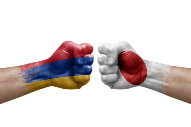 Two hands punch to each others on white background. Country flags painted fists, conflict crisis concept between armenia and japan