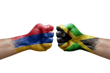 Two hands punch to each others on white background. Country flags painted fists, conflict crisis concept between armenia and jamaica