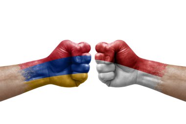Two hands punch to each others on white background. Country flags painted fists, conflict crisis concept between armenia and monaco