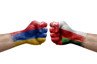Two hands punch to each others on white background. Country flags painted fists, conflict crisis concept between armenia and oman
