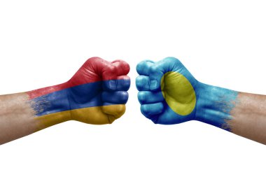 Two hands punch to each others on white background. Country flags painted fists, conflict crisis concept between armenia and palau