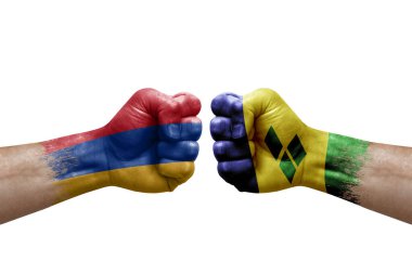 Two hands punch to each others on white background. Country flags painted fists, conflict crisis concept between armenia and saint vincent and the grenadines